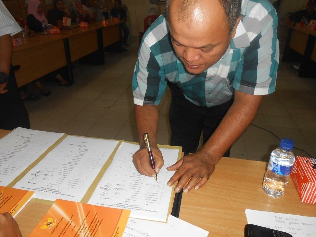 Salah Satu Peserta Rapat Memberikan Tandatangan Kesepakatan Rute Kampanye Damai
